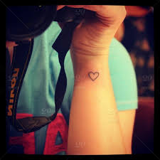 British flag heart tattoo on wrist. A Girl With A Heart Tattoo On Her Wrist In A Blue And Pink T Shirt Holding A Camera Stock Photo Ig 204238914092567371 30799897