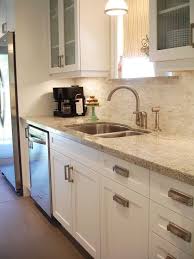 White Shaker Style Cabinets With Modern Brushed Nickel Hardware Kashmir White Grani Trendy Kitchen Backsplash Kitchen Backsplash Designs White Galley Kitchens