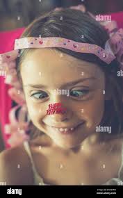 Portrait of little girl with 'Happy gluing Birthday' at her nose Stock  Photo