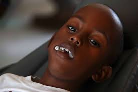 A Haitian boy waits after receiving dental treatment