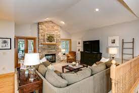 This Family Room Has A Vaulted Ceiling With Bright Recessed Lights And A Dramatic Floor To Ceiling 2 Sided Stone Fireplace Family Room Room Recessed Lighting