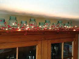 For example, during the holidays, try evergreen branches and large pinecones. Kitchen Cabinets Garland Over Kitchen Cabinets Christmas Garland Above Kitchen Cabinets Abov Mason Jar Decorations Farmhouse Kitchen Decor Primitive Decorating