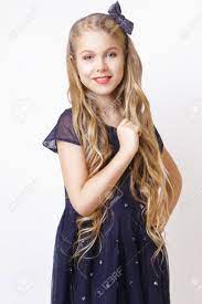 Before styling your little girl's hair, you should detangle it first. Beautiful Little Blonde Girl With Long Wavy Hair In An Elegant Blue Dress Posing In Studio On A White Background Stock Photo Picture And Royalty Free Image Image 98309517