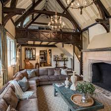 Tudor homes were typically designed with an interior that complemented the exterior in terms of design style. Tudor Style Family Room With Large Stone Fireplace And Loft Tudor Style Homes House Styles Tudor Decor