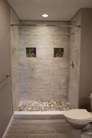 A small bathroom with a shower separate with white long tiles, a printed tile floor, a potted plant and a white vanity a small bathroom with grey long tiles and printed ones on the floor, a graphite grey vanity, touches of gold and a marble countertop Tiled Shower Small Bathroom Bathroom Remodel Designs Shower Tile