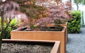 This modern steel planter features a developed patina finish and a sleek wide design. Corten Steel Andes Pot Caragh Nurseries