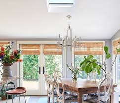 Fabulous kitchen with a peninsula style island featuring white cabinetry, nickel hardware and a marble counter surrounding an undermount. News Interior Design Magazine