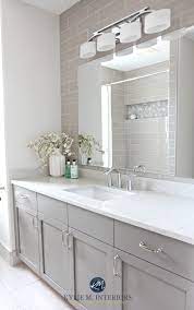Gray french kitchen cabinets are adorned with brass pulls and hold a microwave drawer beneath a marble countertop fixed against a marble backsplash and beneath gray upper cabinets. Our Bathroom Remodel Greige Subway Tile And More Bathroom Design Bathrooms Remodel Trendy Bathroom