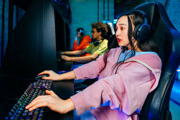 Multiethnic group of young friends playing videogames - Team of  professional esport gamers playing in competitive video
