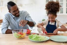 Kitchen it is also worth noting that this book is written and published for an american market, with some of the advice around chains for food being none existent in the u.k. Smiling Young African American Father And Small Ethnic Daughter Chop Vegetable Cook Healthy Vegetarian Salad Together Happy Biracial Dad And Little Girl Child Have Fun Preparing Food In Home Kitchen Stock Photo