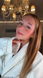 Harper Beckham, 13, is glued to her phone as she steps out in Paris holding  £1,850 Goyard tote bag while stylish mother Victoria tries to keep low-key 