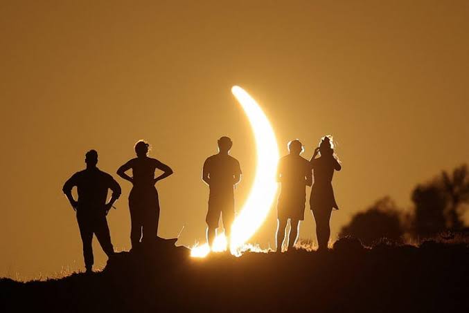 Spectators watch as the moon completely obscures the sun during the 2026 total solar eclipse over Europe.