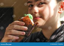 Teenager Boy with Thick Eyebrows Holds a Cupcake in His Hand Stock Image
