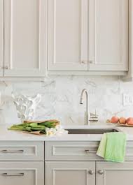 Light Gray Raised Panel Kitchen Cabinets Adorned With Satin Nickel Pulls Are Fitted Greige Kitchen Cabinets Cheap Kitchen Cabinets Outdoor Kitchen Countertops