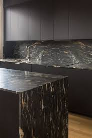 Contemporary kitchen with black cabinets, marble counter backsplash and chandelier. 25 Ultimate Black Kitchen Designs That Wow Shelterness