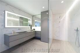 Glass walls on two sides of the corner shower make the bathroom feel larger and welcome light from a nearby window. Bath Design Custom Bathroom White Stone Bathroom Design From Iceland Stonecontact Com