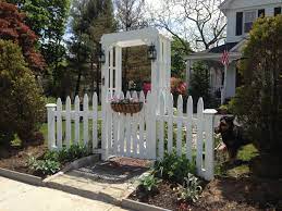 This diy white picket fence gate was the solution to my problems of wanting a stylish looking gate, that was affordable, and was going to keep my kids and dog safe in the backyard. White Picket Fence Garden Gate And Arbor White Picket Fence Garden Garden Gates White Picket Fence
