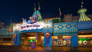 Night View Of Peter Pan S Flight With Statues Of Peter Pan Wendy And Her Brothers Above Its Sign Disney World Rides Peter Pans Flight Disney World