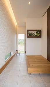 玄関はエコカラットを壁一面に貼り 間接照明で照らしています エコカラットは消臭効果があり 機能性とデザインを兼ね備えたアイテムです 土間が勝手口まで続いているので 靴のまま裏庭へ出ることができます 玄関 内装 玄関ホール インテリア 家