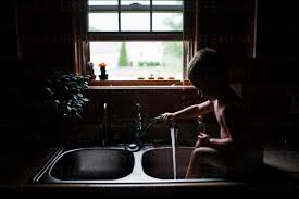 playful boy washing legs while sitting
