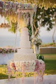A boho handpainted wedding cake in traditional fall colors topped with a sugar flower is great. A Suspended Tiered Wedding Cake Adorned With Flowers Pastel Floral Wedding Decor Inspiration Suspended Wedding Cake Hanging Cake Floral Wedding Cakes