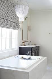 Black And White Roman Shades A White Beaded Chandelier Accents A Window Covered In A Black And White Roman Shade Hung Over A Ma Roman Shades Bathroom Bathroom Decor Custom Window Coverings
