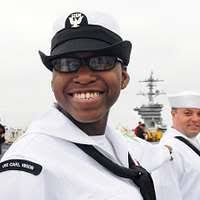 Fire Controlman 2nd Class Randy Kabbourim shows a child