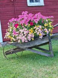 38 beautiful and inexpensive diy ideas to equip a flower garden in front of the house my desired home in 2021 wheelbarrow planter garden containers container flowers