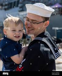 SAN DIEGO (March 4, 2022) Machinist's Mate 2nd Class Seth Borden, from  Gresham, Ore., meets his newborn child for the first time after completing  a seven-month deployment aboard amphibious assault ship USS