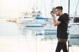 The term cameraman does not imply that a male is performing the task. Great Day For Photoshooting Creative And Talented Young Cameraman Standing In Profile Near Seashore In Harbour While Stock Image Image Of Nature Hipster 111819745