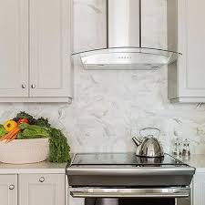 Stainless Steel And Glass Range Hood With Marble Backsplash Glass Range Hood Light Grey Kitchen Cabinets Light Grey Kitchens