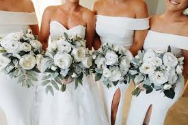 Stargazer lilies stretch their fuchsia petals out amongst an arrangement of blue iris, white traditional daisies, orange mini carnations, purple statice and yellow solidago in a round whitewash handled basket, creating a delightful bouquet your special recipient will adore. 10 Divine All White Wedding Bouquets Weddingsonline