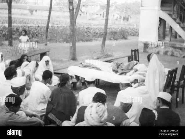 Mahatma Gandhi resting outside ; People sitting next to him on the ground ; 1944 ; India Stock Photo - Alamy