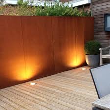 Sichtschutz Aus Cortenstahl In Kombination Mit Einer Angrenzenden Hecke Mit Bodenstrahlern Beleuchtet So Kan Garten Design Gartenzaun Terrassengestaltung