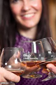 Group Of Friends A Toast To The Cheers Of Cognac Or Brandy Stock Photo