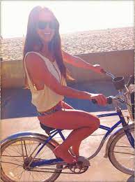 Alex Curry riding her bike on the beach (x