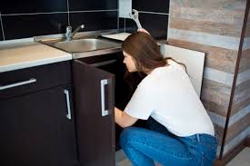 Jeune Femme En Cuisine Personne De Sexe Feminin Fixant Le Tuyau Qui Fuit Sous L Evier Tenez La Cle En Main Seul Dans La Fixation De La Cuisine Photo Premium