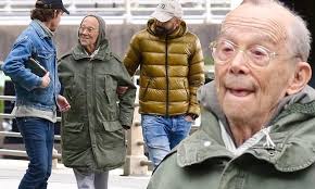 Cabaret star Joel Grey, 91, flashes a smile while out