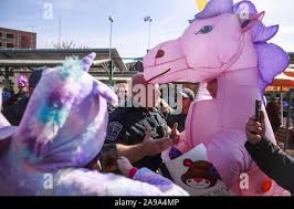A policeman asks Forrest Gilmore to leave the Bloomington Community Farmers  Market during the protest. police arrested activists dressed as a giant  unicorn, Wonder Woman and Vikings after they demonstrated at a