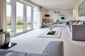 An ivory carpet and couch, taupe tables and walls, and purple accessories. Grey Living Room Ideas Taylor Wimpey