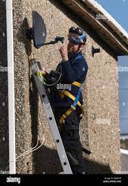 Sky Tv Engineer Installing Satellite Dish, Cornwall, Uk Stock Photo - Alamy