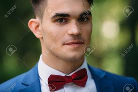Brown curly hair for long haired guys. A Close Up Dark Haired Guy With Thick Eyebrows Brown Eyes And Freckles Gazes Intently At The Camera A Man In A Blue Suit And With A Bright Butterfly Grins Stock Photo Picture And