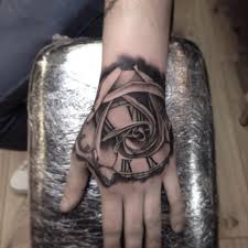 It's for percy putting down his weapons and choosing to make the world a better place through his art and science, using one of vex's feathers as a clock rose morph tattoo. Grey Ink Rose Clock Tattoo On Left Hand By Paul Priestley