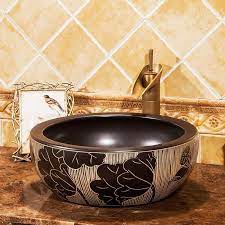 Basin mixer taps have one water outlet, where hot and cold water are mixed together in the pipework. European Style Round Artistic Basin Wash Basin Countertop Bathroom Sinks Wash Basin Black Lotus Carving Wash Basin Bathroom Countertops Basin