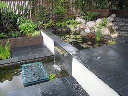 Koi Pond Garden With Stainless Steel Waterfall Blade Glass Stepping Stone Rendered Walls Sleeper Beds Bla Landscaping With Rocks Garden Design Glass Garden