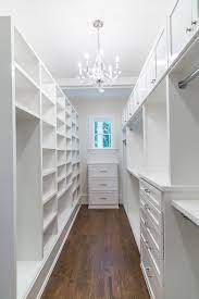 Kate H Design Long And Narrow Closet Space With White Cabinets And Visual Comfort George Chandelier Narrow Closet Design Closet Remodel Closet Layout