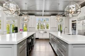 The large ceiling beams add a roughness to the design. Ksi Kitchen Solutions Double Island Gray And White Kitchen Is A Modern