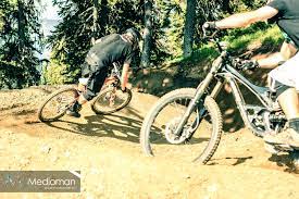 mountainbiking in the bikepark schladming planai in 2012 going fast on the upper section of the downhill track two riders shredding the perfect mountainbike