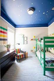 A chandelier, a frilly dollhouse and a colorful quilt add feminine touches to the fun space. 39 Approved Ways For Painting Interior Ceilings Boys Room Paint Colors Boy Room Paint Kids Room Paint Colors