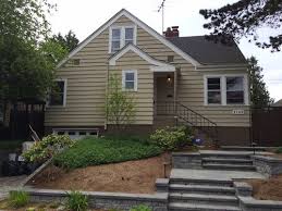 The front door and shutters are a gloss black and look very rich. Exterior House And Foundation Colors To Go With Black Roof And Stone E